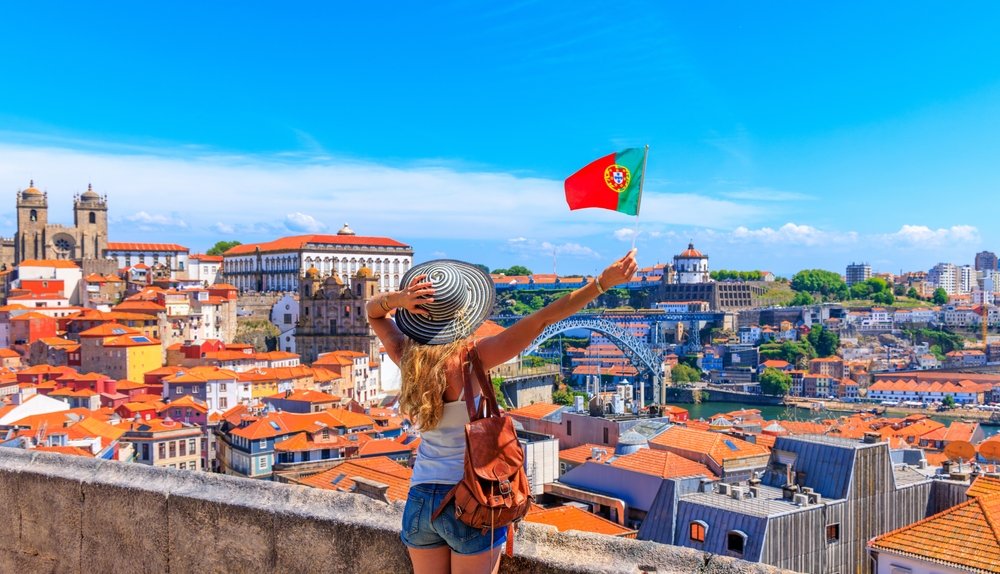Woman,Tourist,Holding,Portuguese,Flag,In,Front,Of,Panoramic,Viewpoint