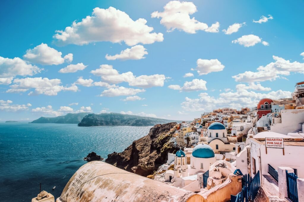 pexels-photo-1285625-1285625 Captivating view of Santorini's famous blue-domed buildings under a vibrant sky.